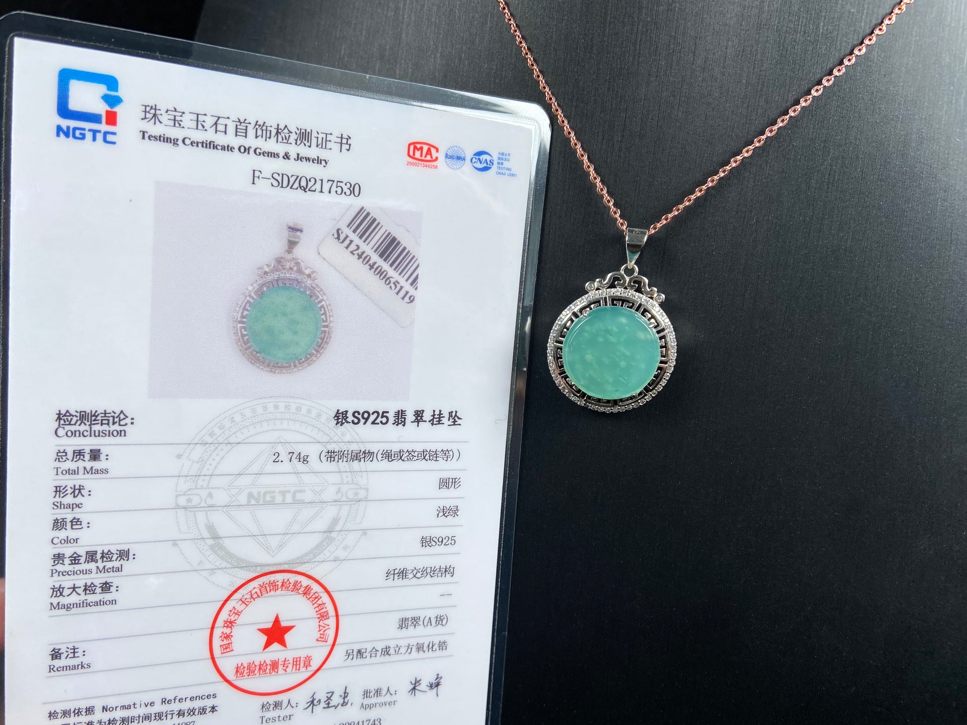 Necklace with jadeite pendant and NGTC certification card on a black background