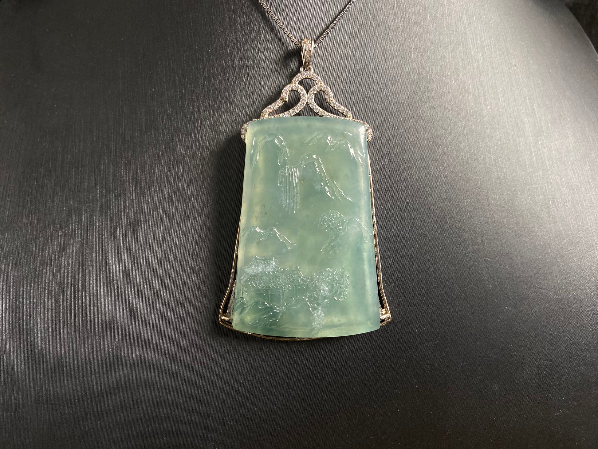 This jade pendant is a light green landscape plaque.