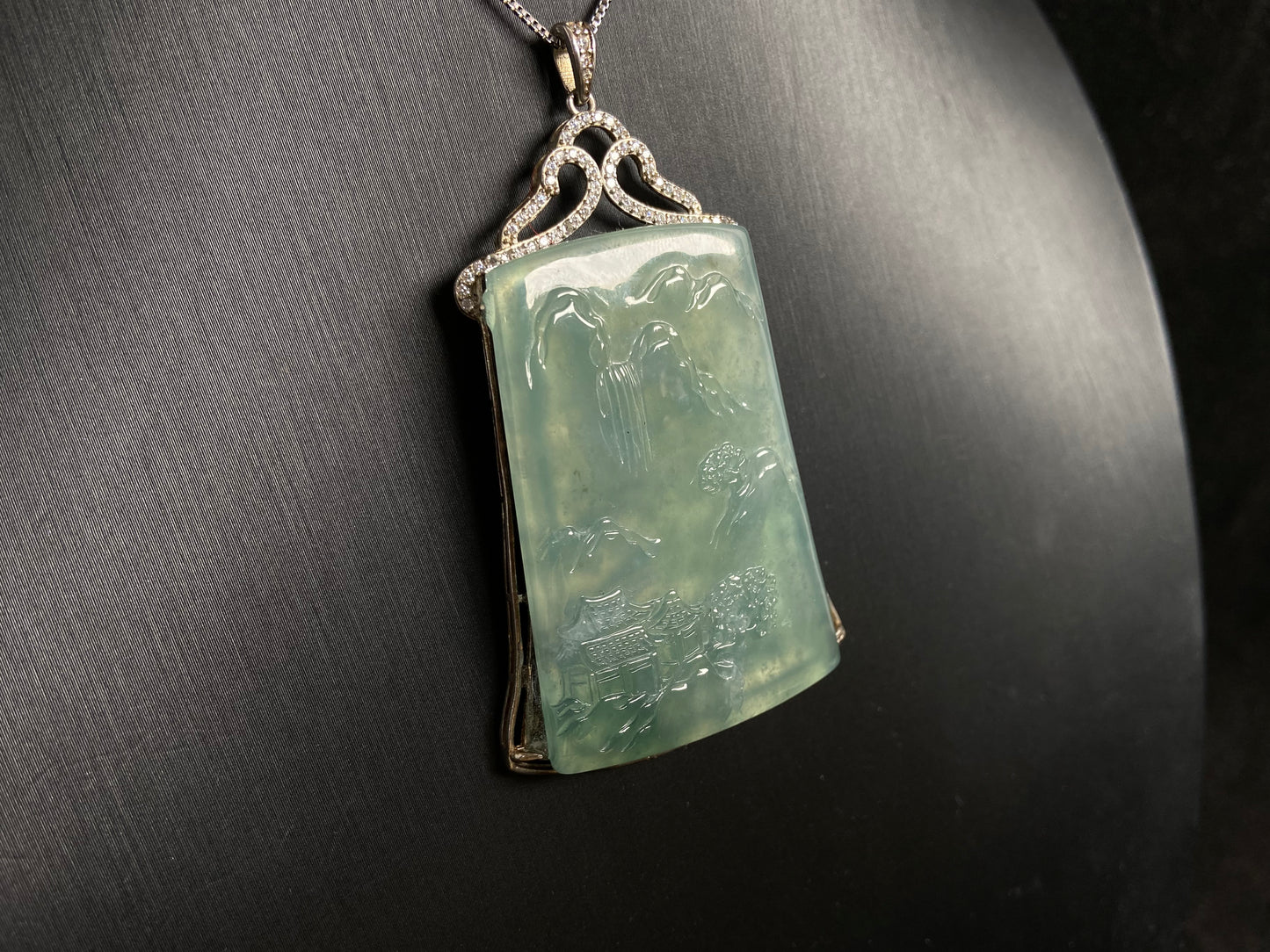 This jade pendant is a light green landscape plaque.