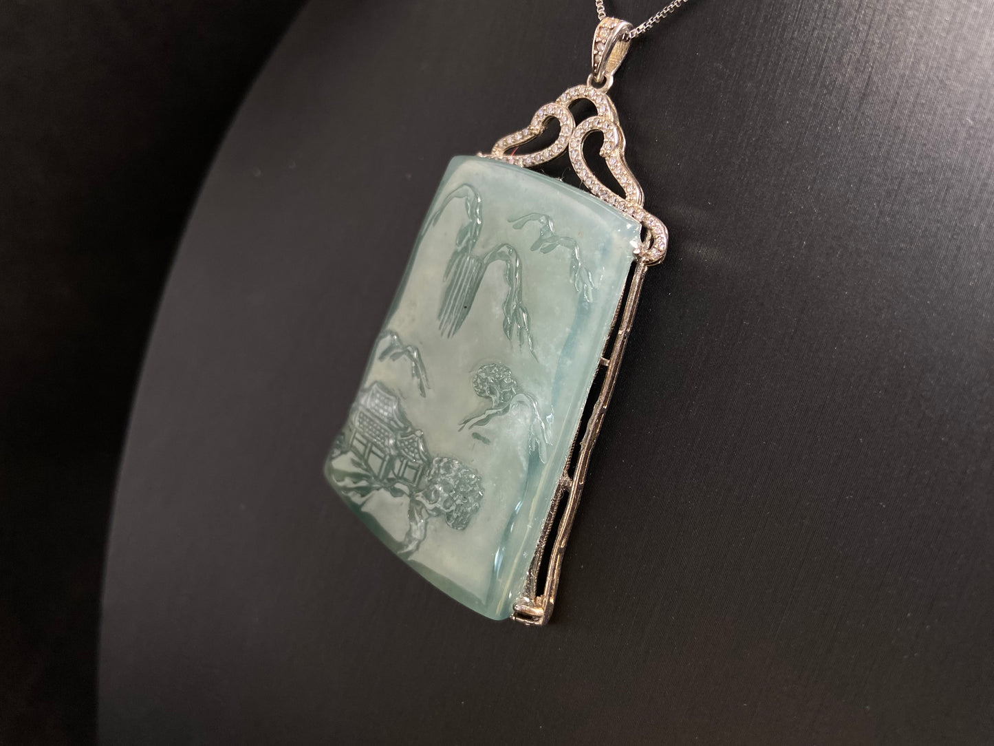 This jade pendant is a light green landscape plaque.
