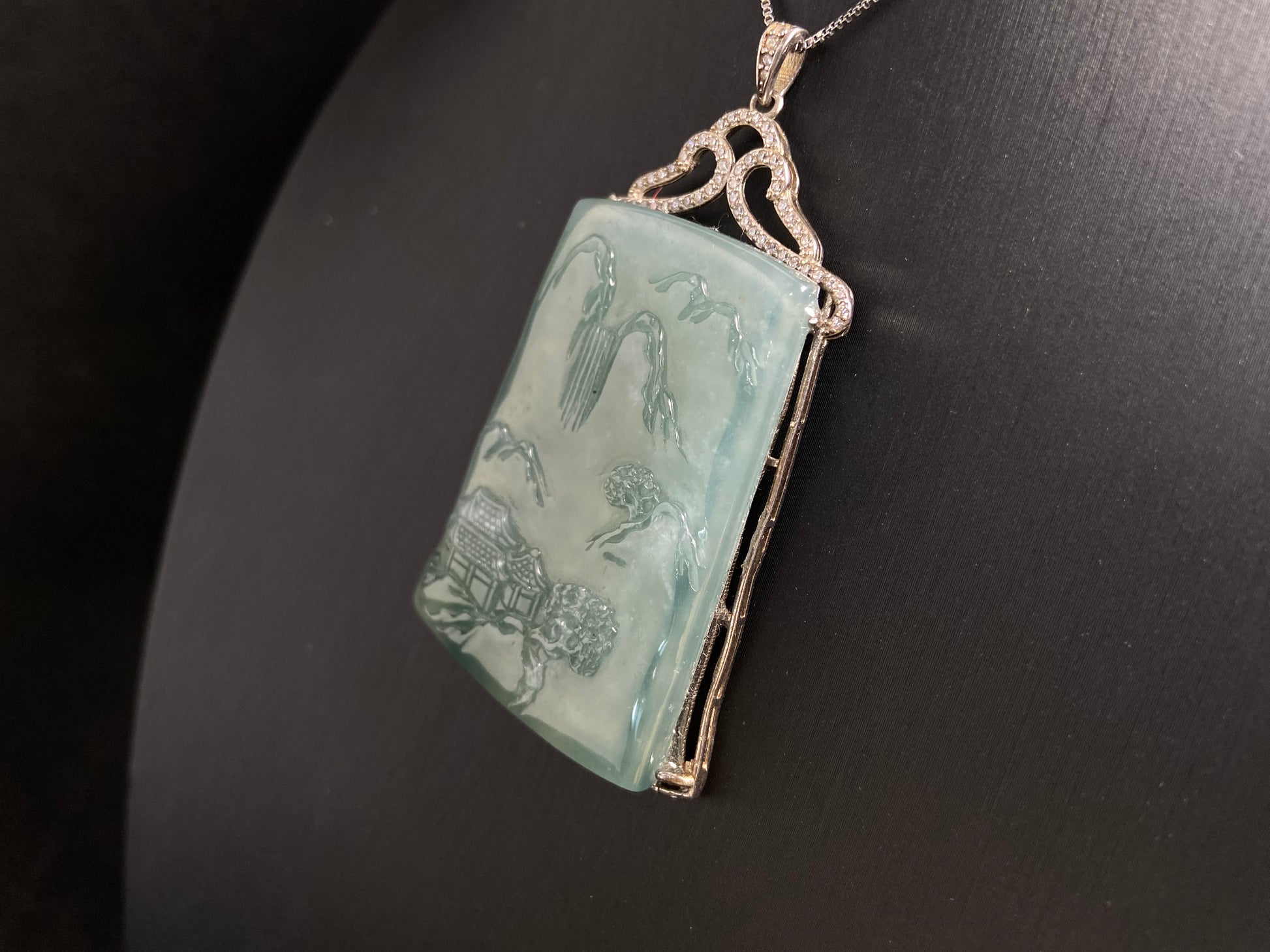 This jade pendant is a light green landscape plaque.