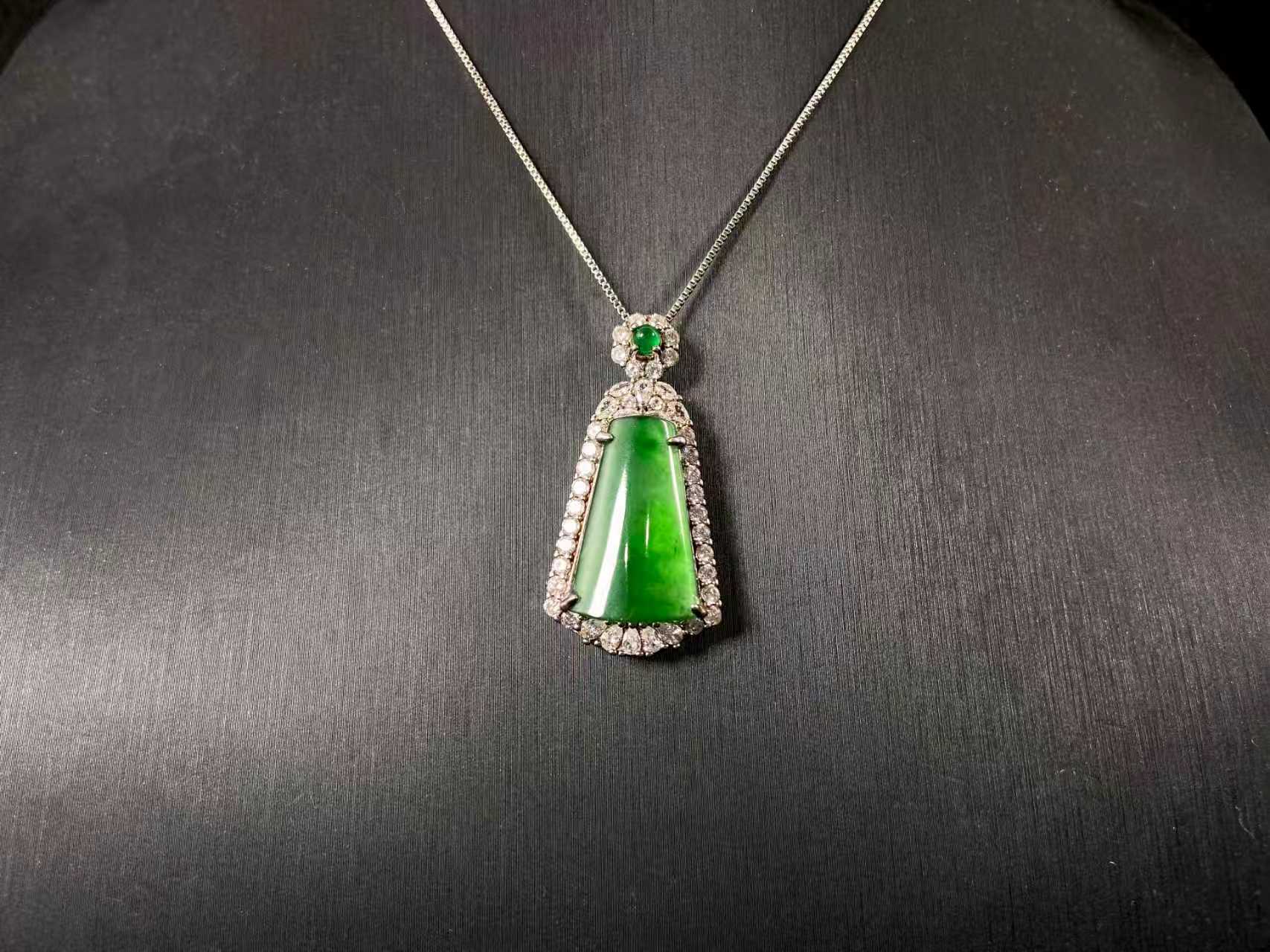 A transparent green jade “harmony plaque” symbolizing peace and freedom from worldly troubles, is elegantly framed in 925 sterling silver.