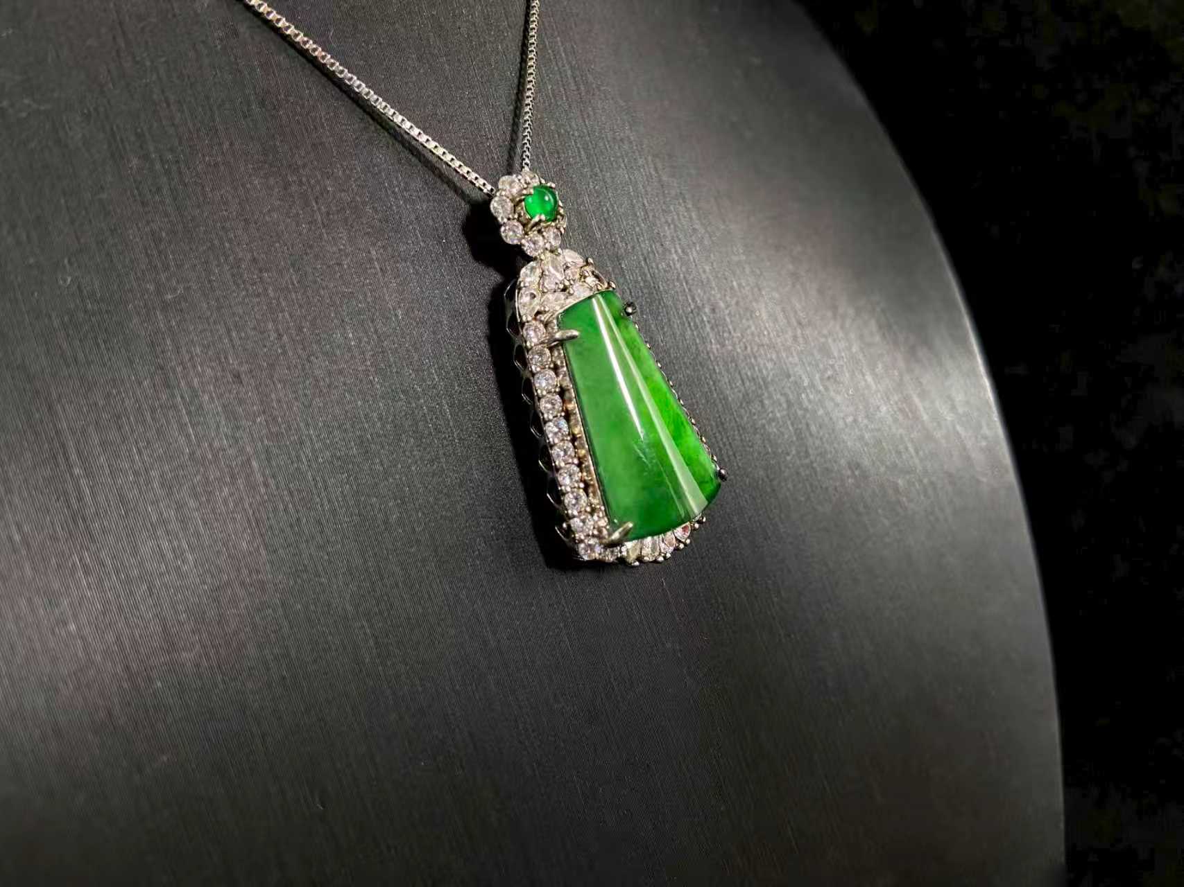 A transparent green jade “harmony plaque” symbolizing peace and freedom from worldly troubles, is elegantly framed in 925 sterling silver.
