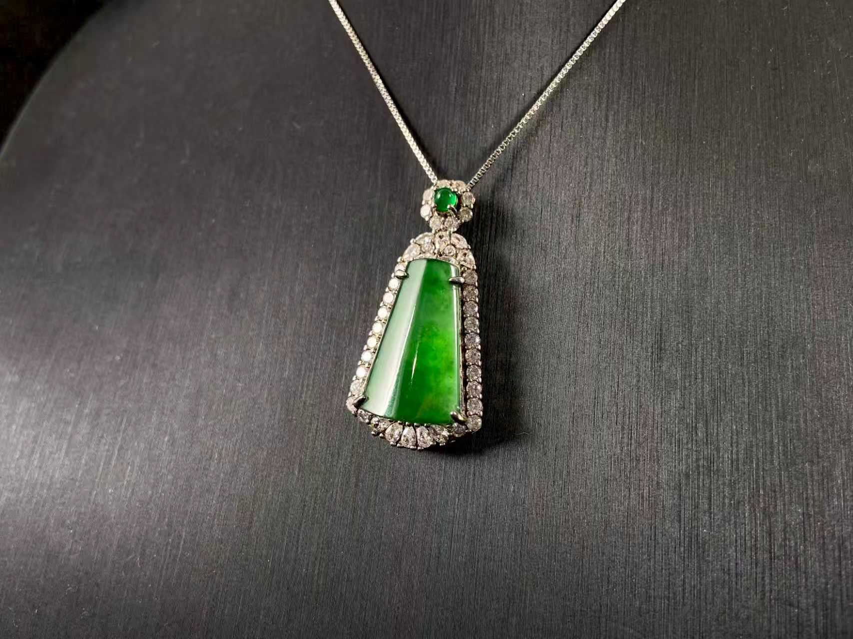 A transparent green jade “harmony plaque” symbolizing peace and freedom from worldly troubles, is elegantly framed in 925 sterling silver.