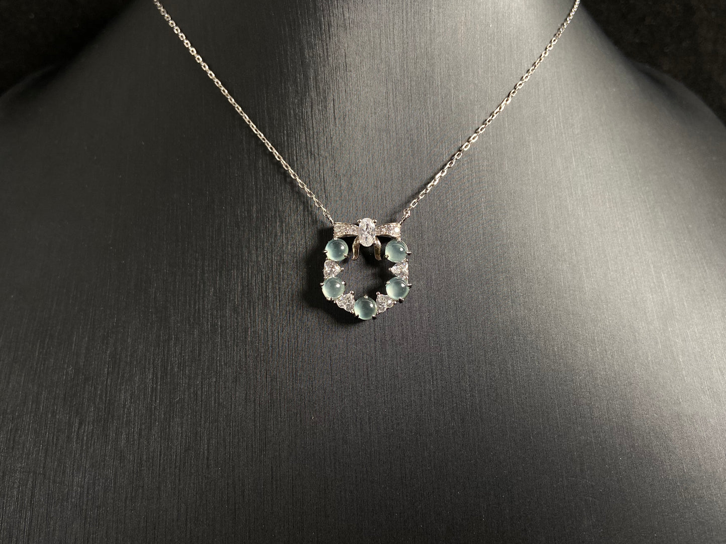 A pendant featuring five pale blue translucent jade beads, accented with diamonds and set in 925 silver.