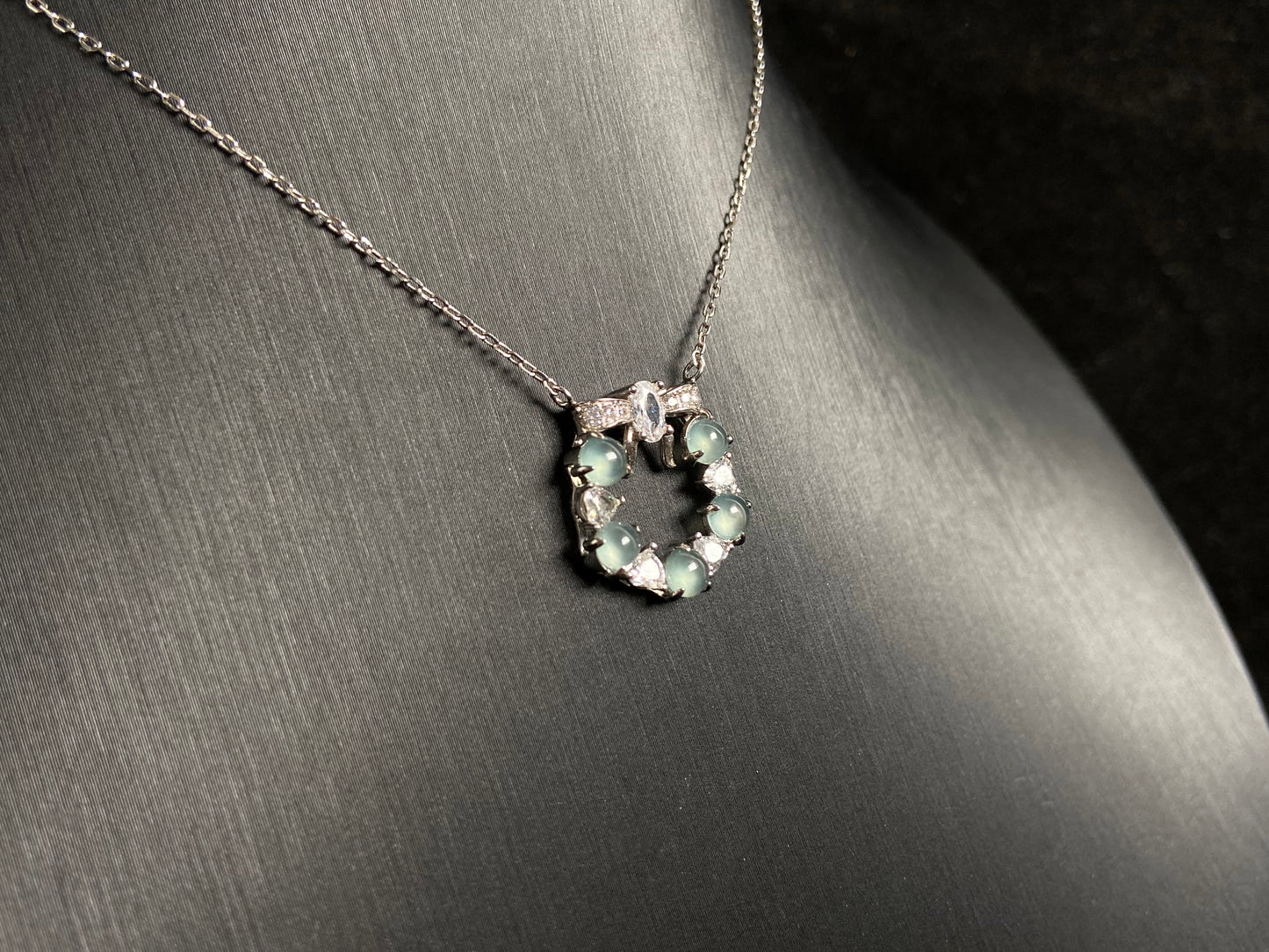 A pendant featuring five pale blue translucent jade beads, accented with diamonds and set in 925 silver.