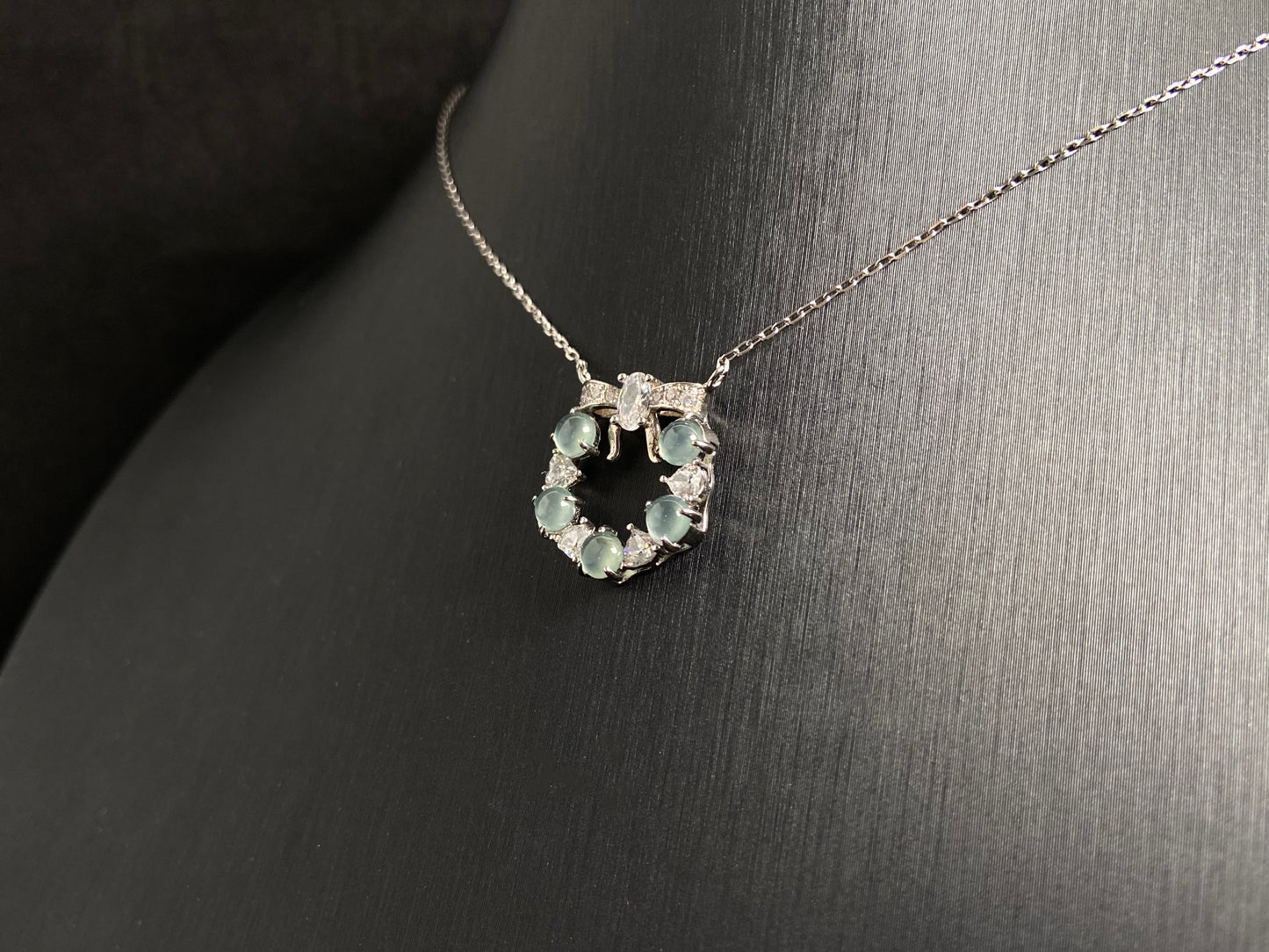 A pendant featuring five pale blue translucent jade beads, accented with diamonds and set in 925 silver.
