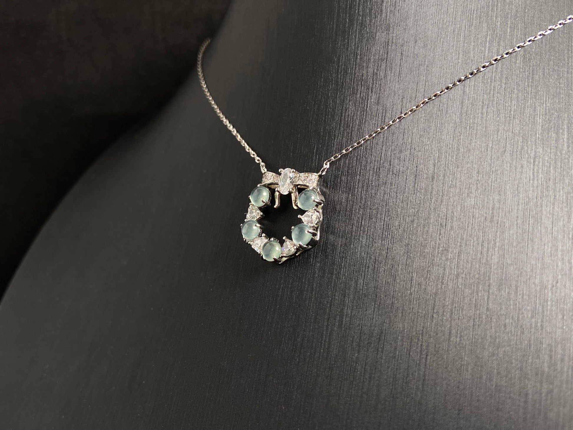 A pendant featuring five pale blue translucent jade beads, accented with diamonds and set in 925 silver.