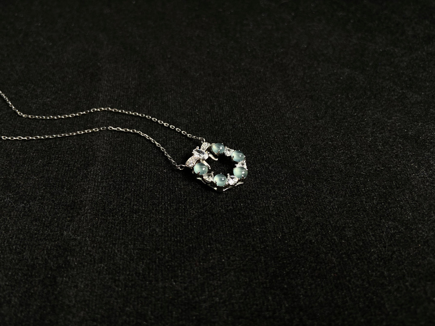 A pendant featuring five pale blue translucent jade beads, accented with diamonds and set in 925 silver.