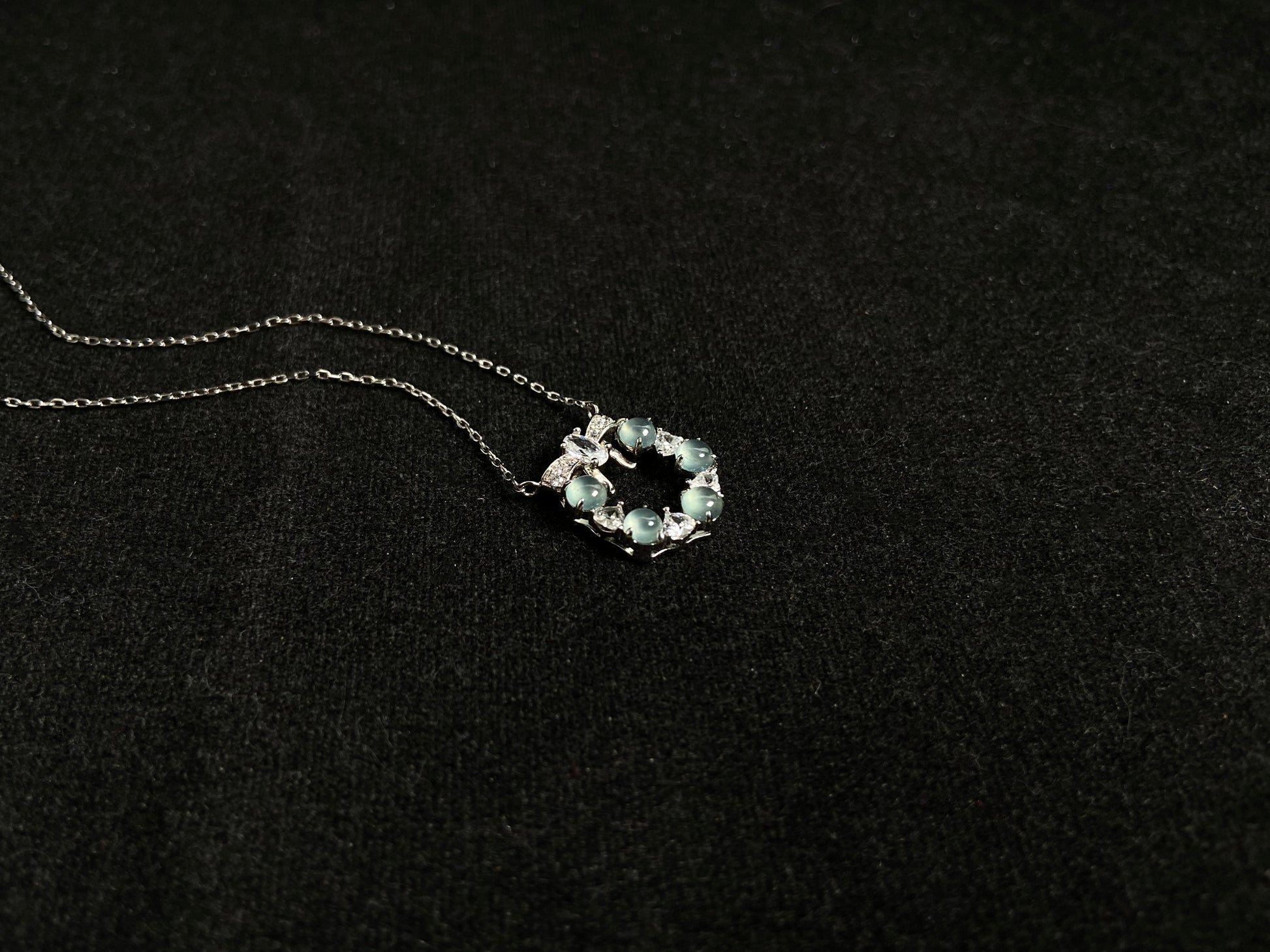 A pendant featuring five pale blue translucent jade beads, accented with diamonds and set in 925 silver.