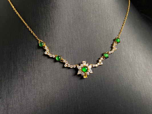 A pendant with five green jade beads one centered in a gold plated 925 silver floral setting, flanked by four accent beads.