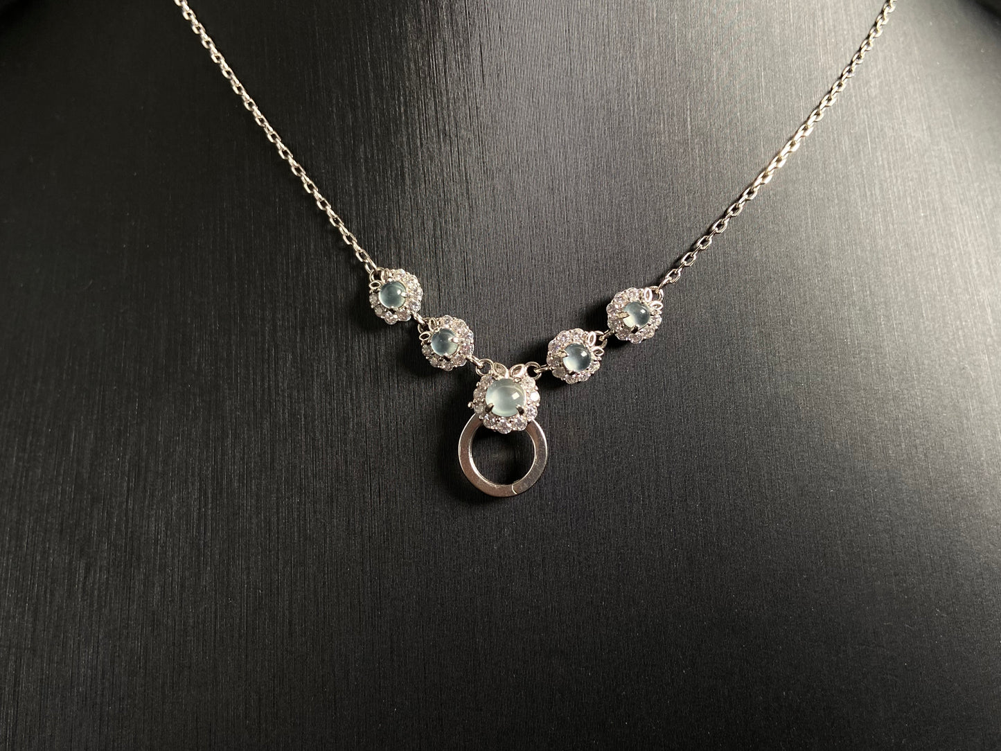A jade pendant featuring five icy toned beads, each elegantly set in 925 silver.