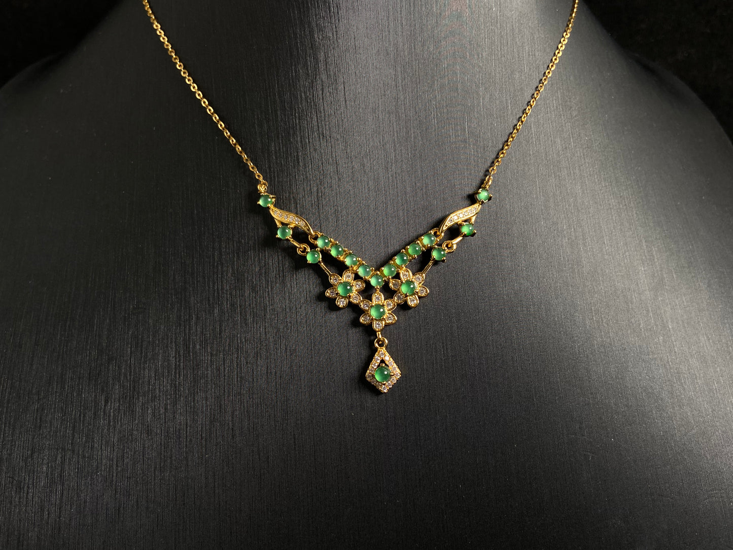 A delicate pendant featuring 19 transparent green jade beads, elegantly set in gold plated 925 silver.