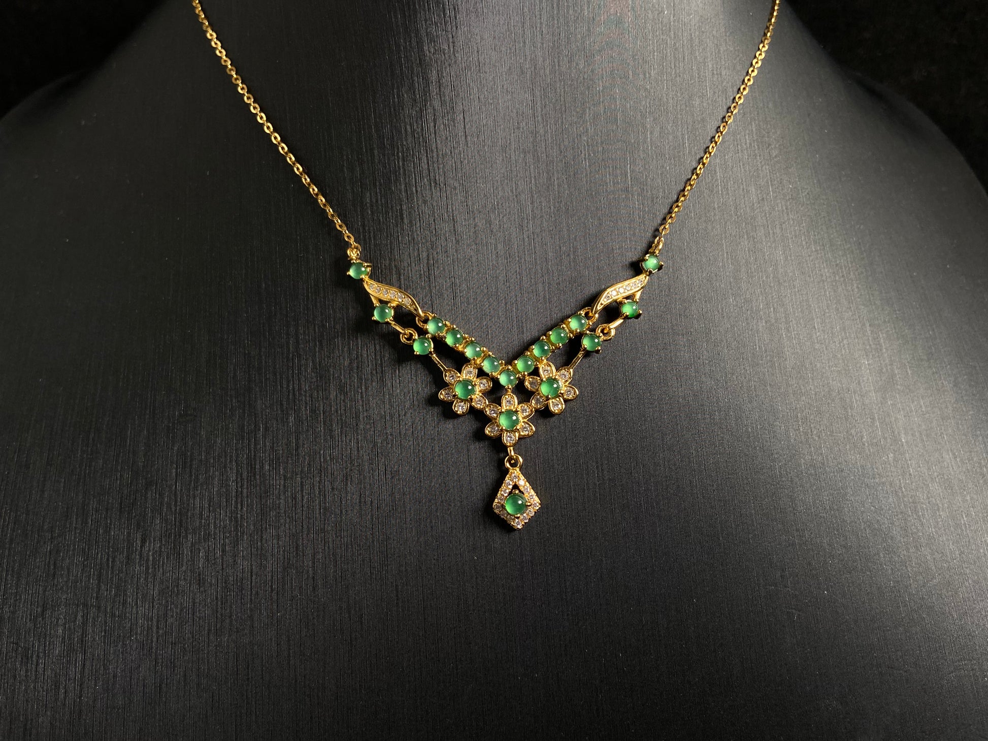 A delicate pendant featuring 19 transparent green jade beads, elegantly set in gold plated 925 silver.