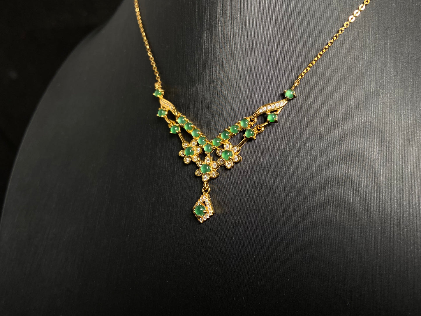 A delicate pendant featuring 19 transparent green jade beads, elegantly set in gold plated 925 silver.