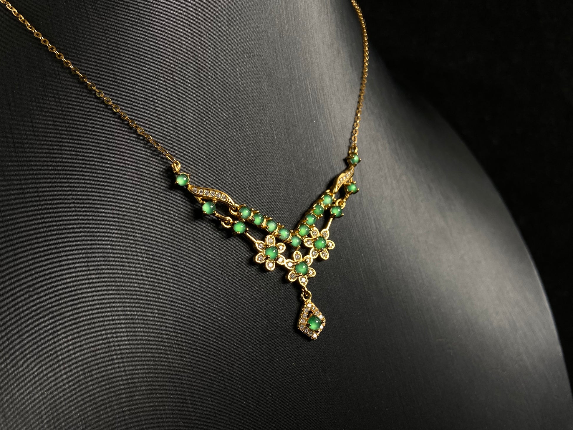 A delicate pendant featuring 19 transparent green jade beads, elegantly set in gold plated 925 silver.