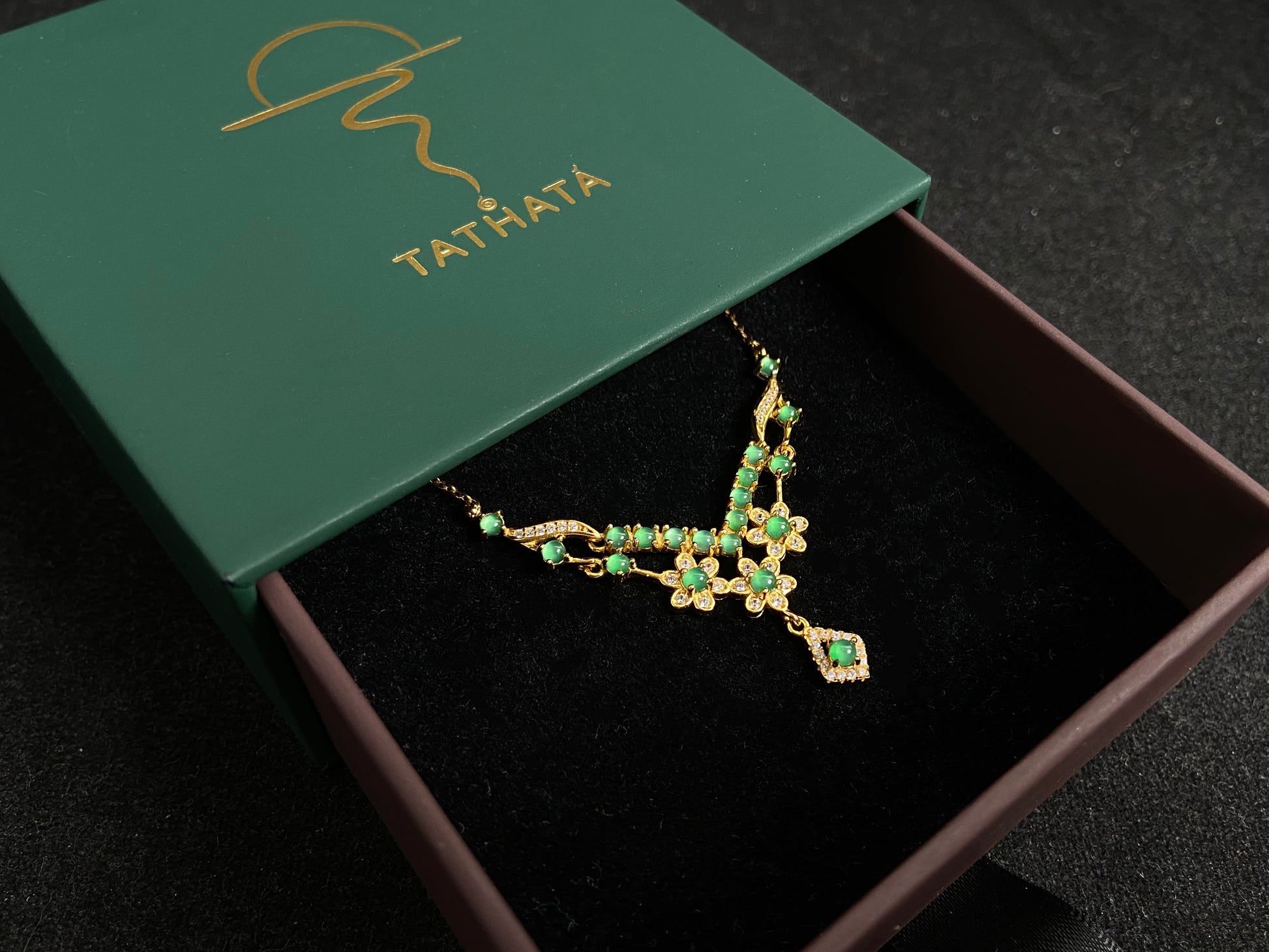 A delicate pendant featuring 19 transparent green jade beads, elegantly set in gold plated 925 silver.