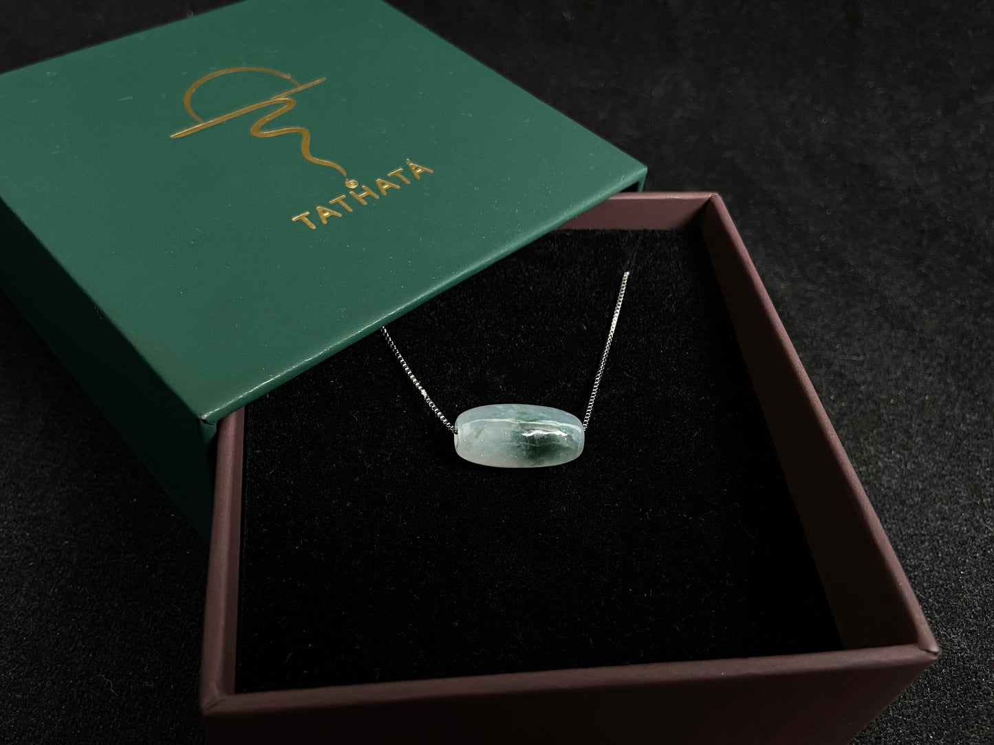 This "Lulutong" jade pendant features a translucent white base adorned with a wisp of green.
