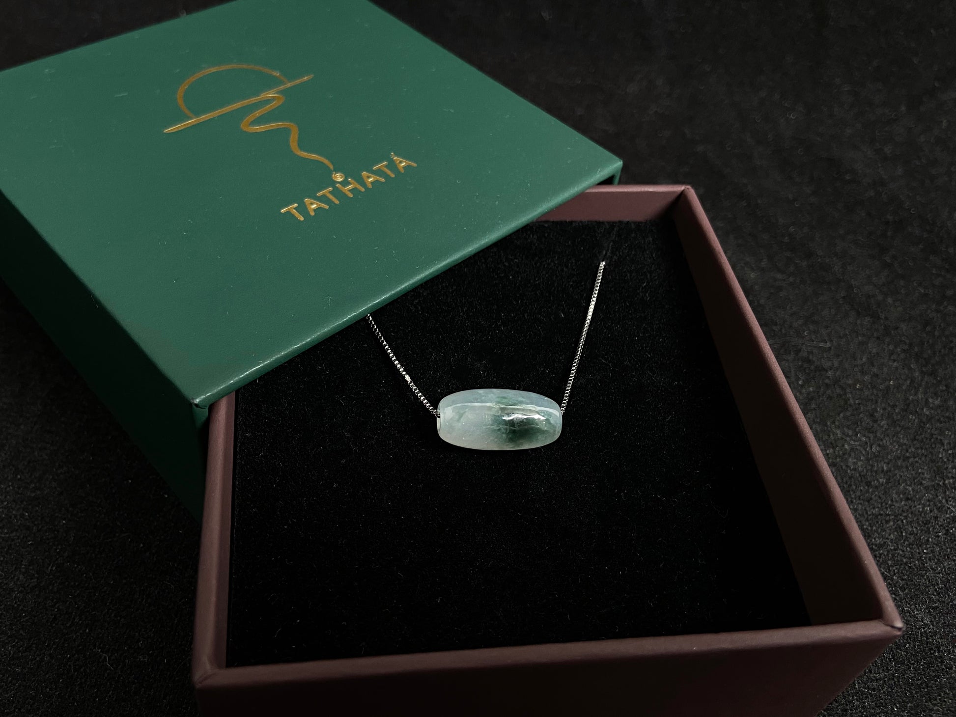 This "Lulutong" jade pendant features a translucent white base adorned with a wisp of green.