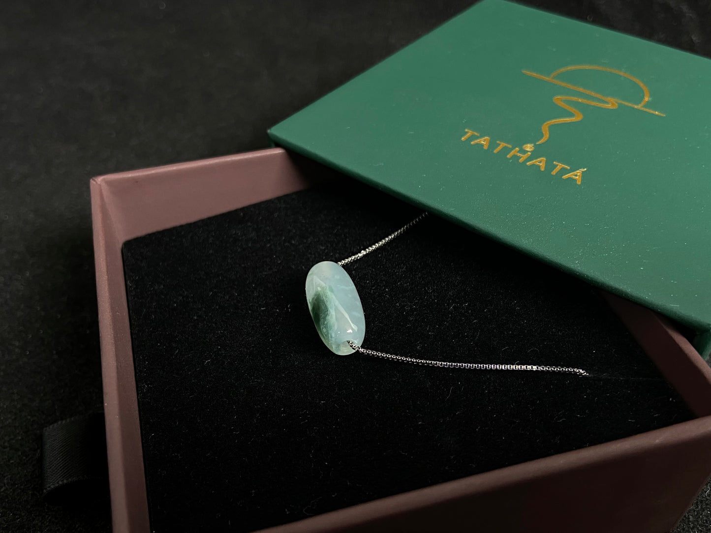 This "Lulutong" jade pendant features a translucent white base adorned with a wisp of green.