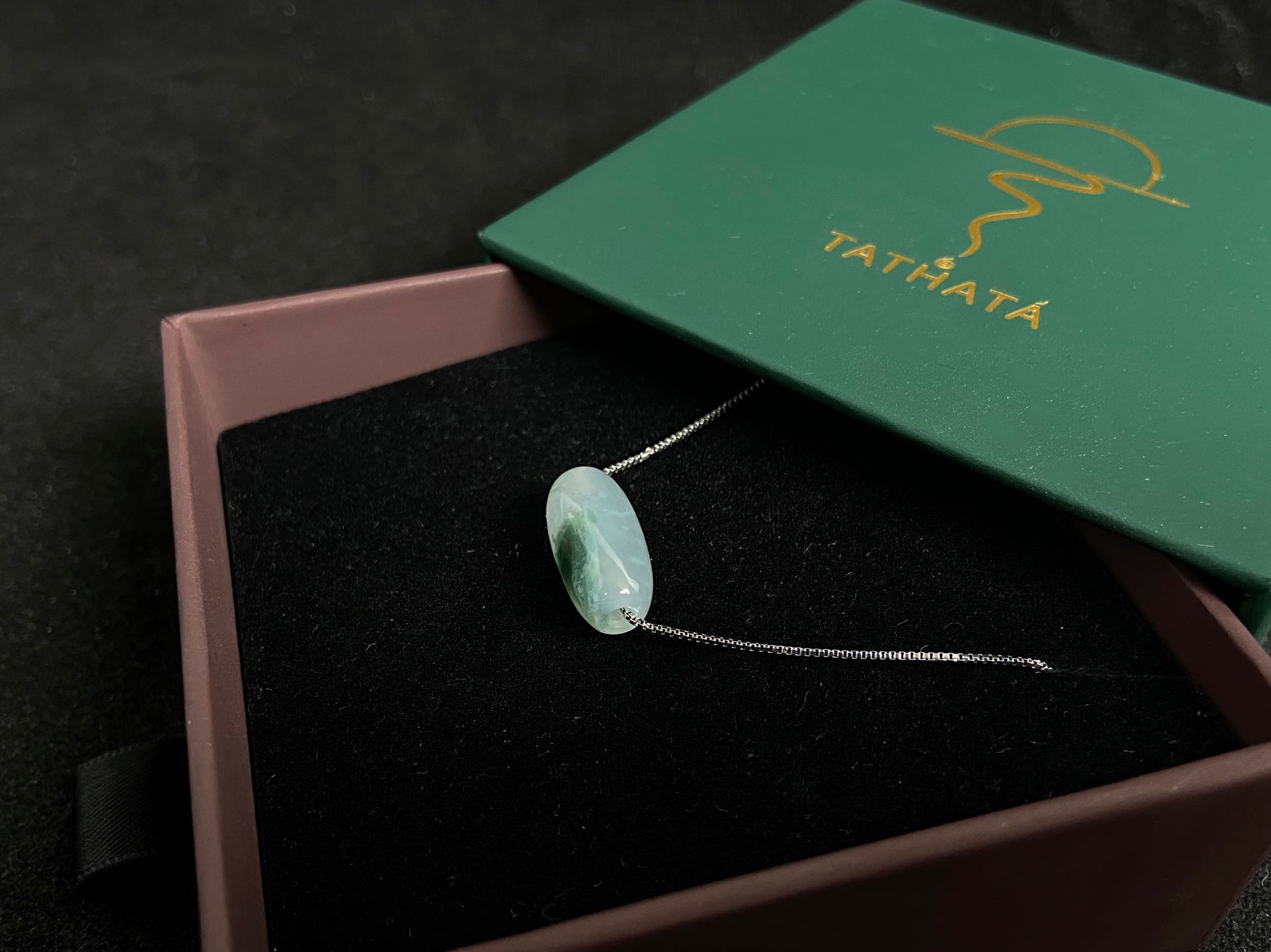 This "Lulutong" jade pendant features a translucent white base adorned with a wisp of green.