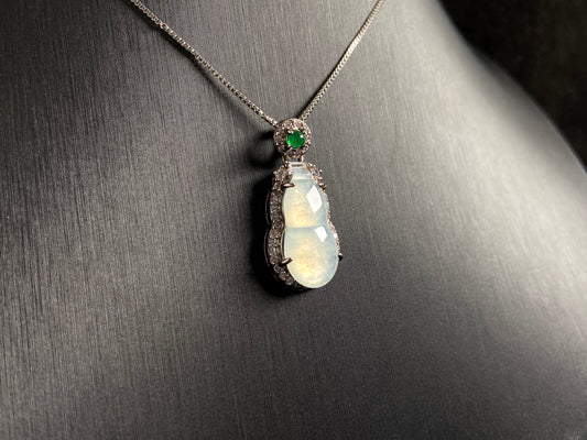 An icy jade gourd pendant with a vibrant green jade bead atop, framed in 925 silver.