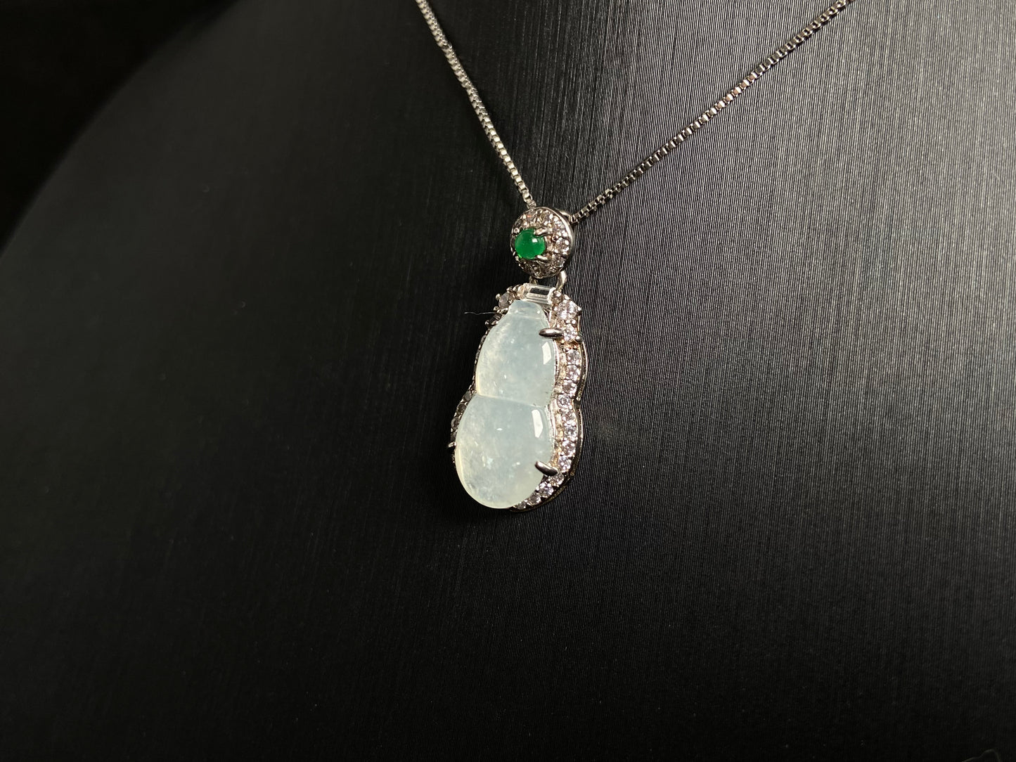 An icy jade gourd pendant with a vibrant green jade bead atop, framed in 925 silver.