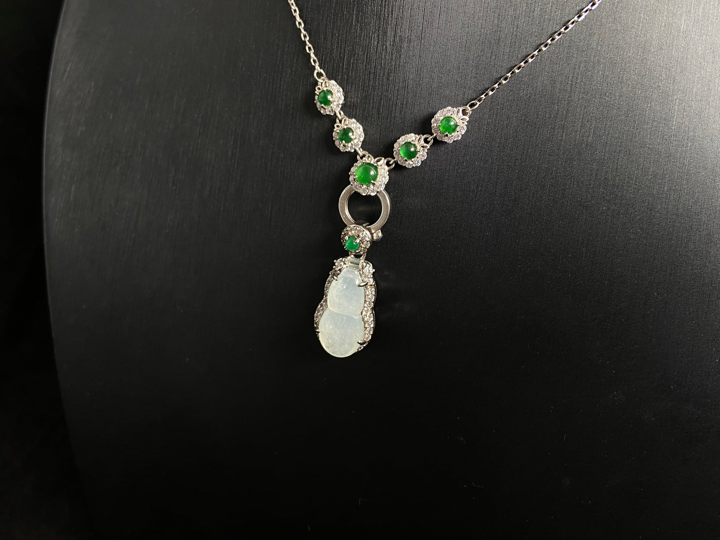 An icy jade gourd pendant with a vibrant green jade bead atop, framed in 925 silver.