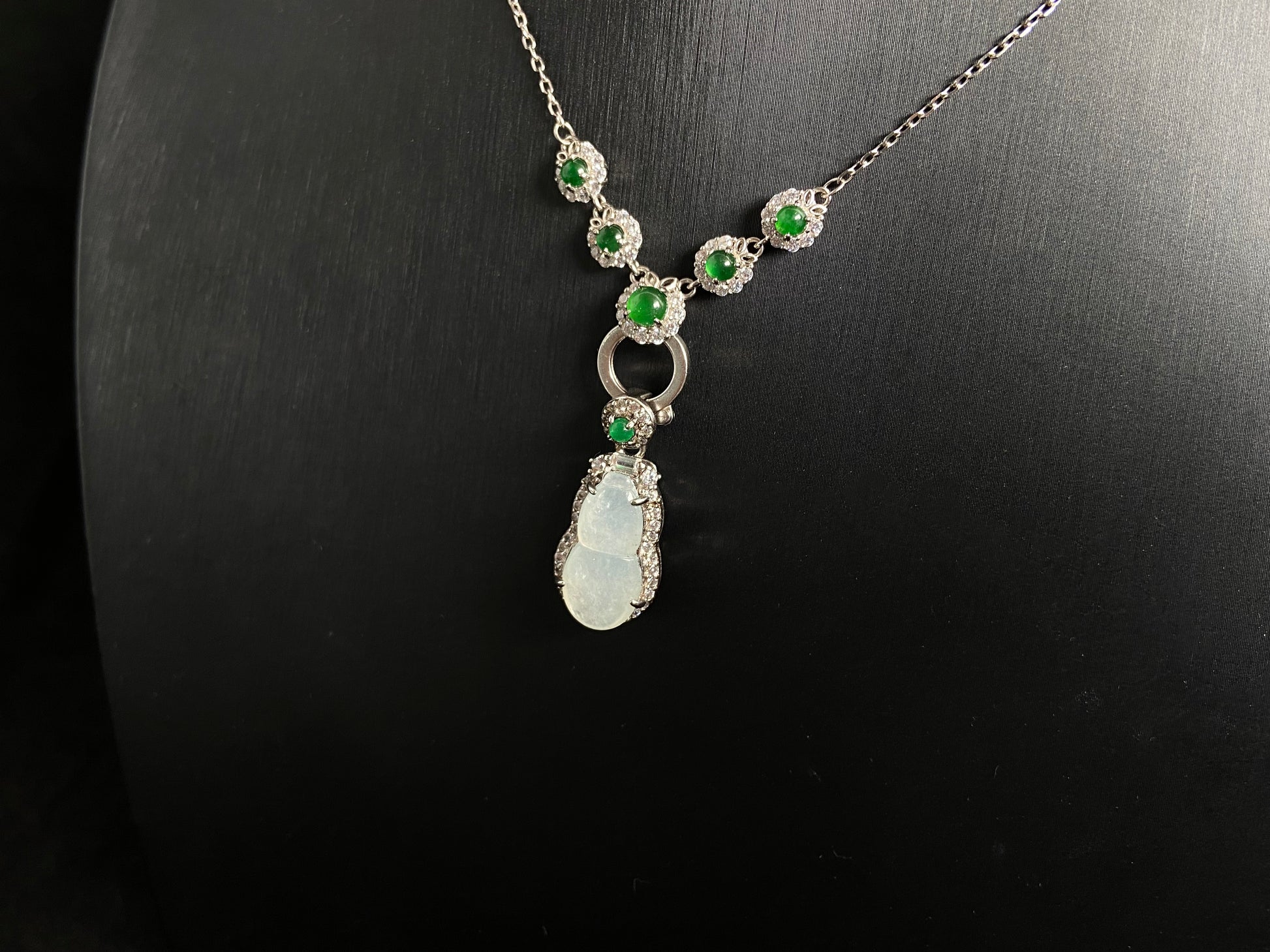 An icy jade gourd pendant with a vibrant green jade bead atop, framed in 925 silver.