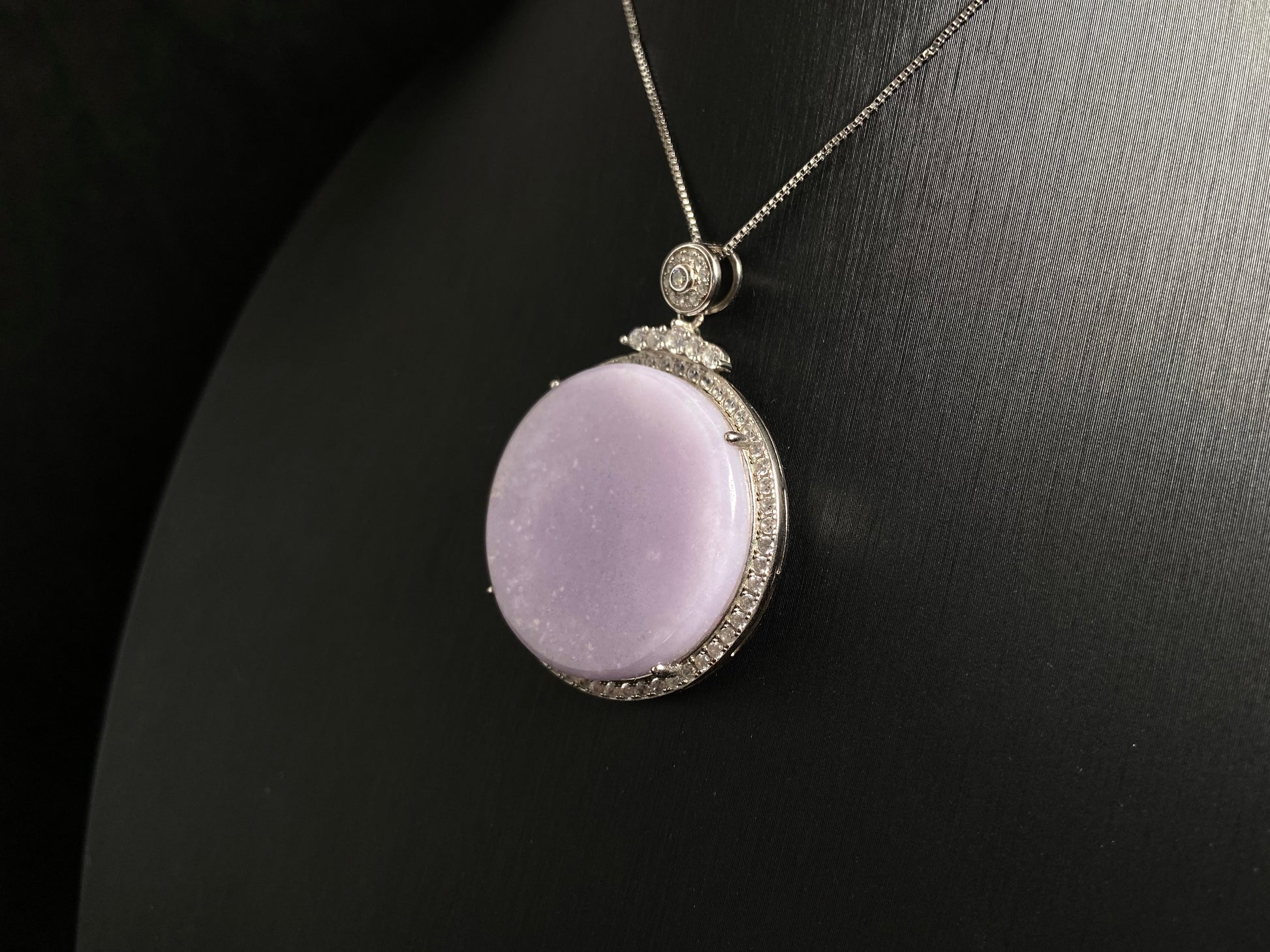 A circular purple jade pendant, elegantly framed in a 925 silver border.
