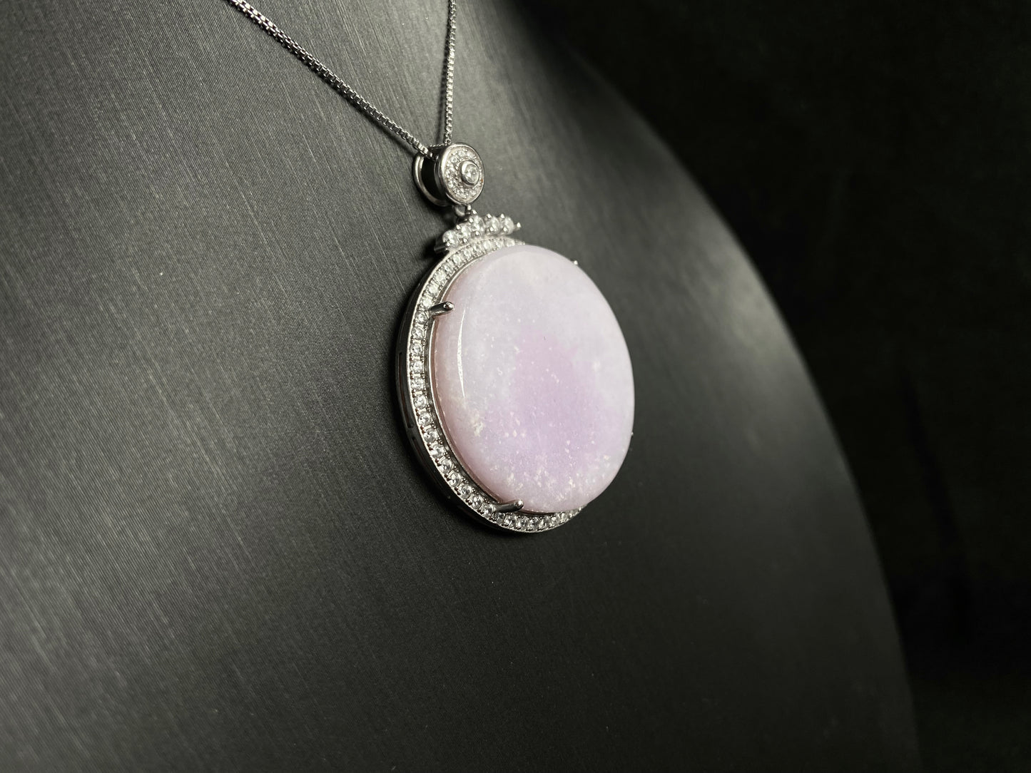 A circular purple jade pendant, elegantly framed in a 925 silver border.