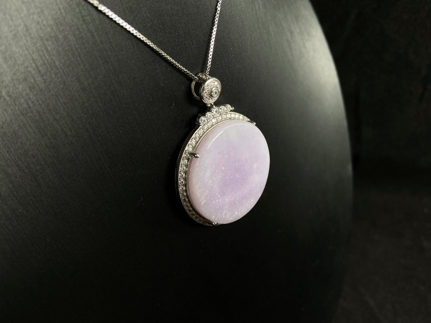 A circular purple jade pendant, elegantly framed in a 925 silver border.