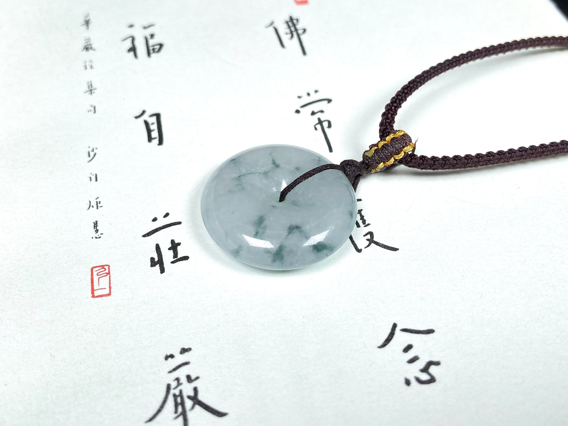 A blue green Ping An Kou jadeite pendant.