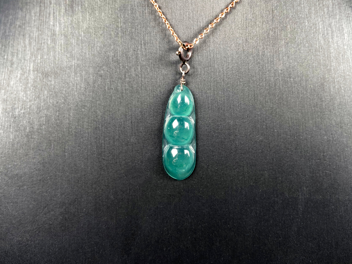 A watery blue lucky pea pod jadeite pendant.