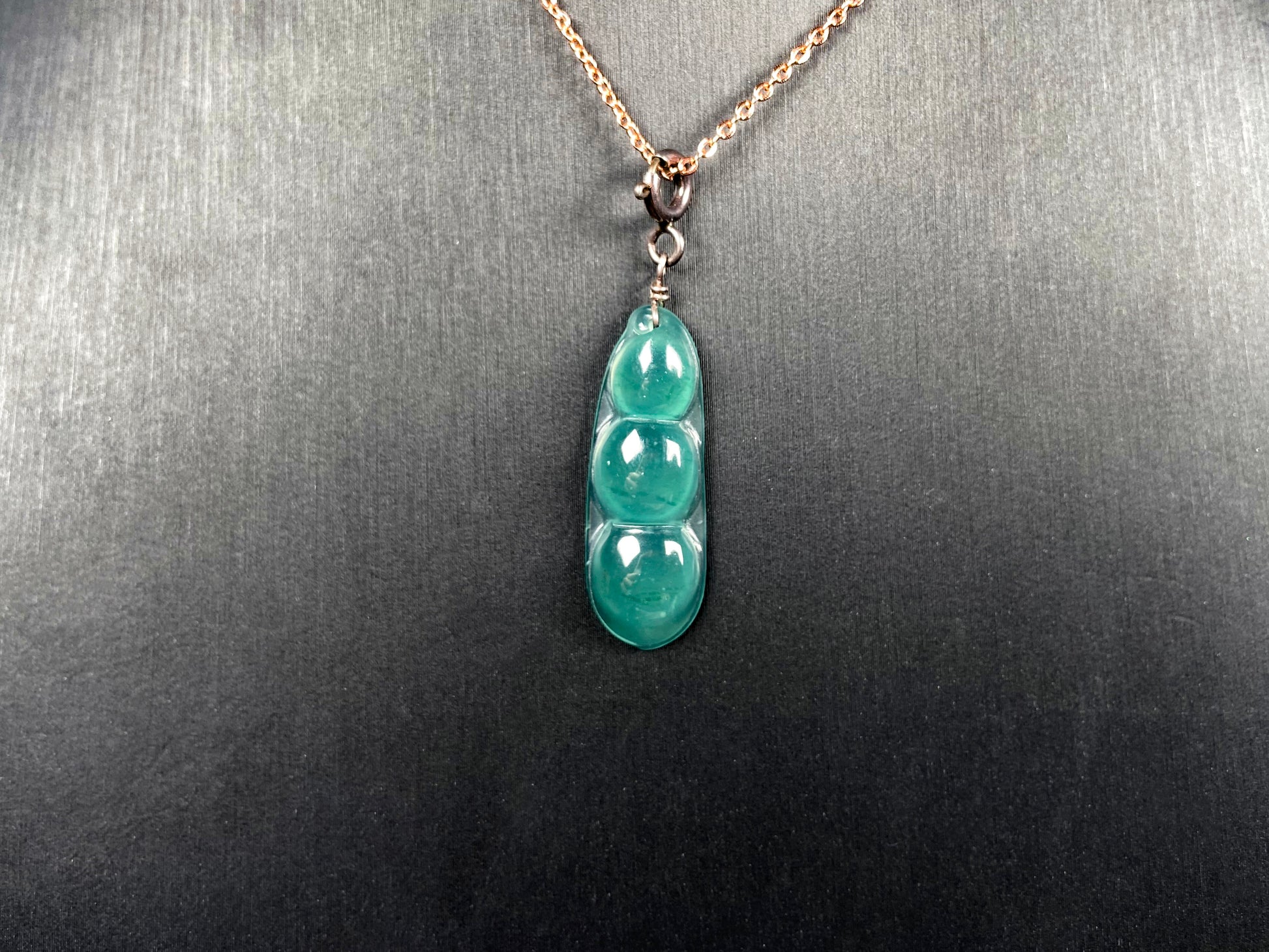 A watery blue lucky pea pod jadeite pendant.