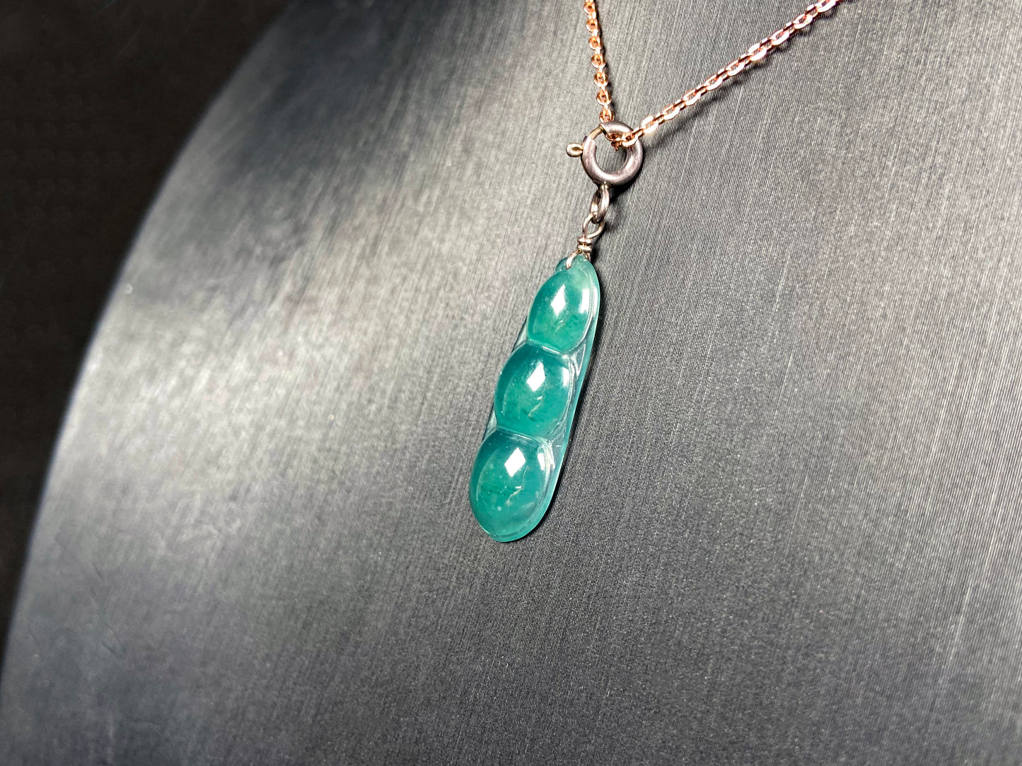 A watery blue lucky pea pod jadeite pendant.