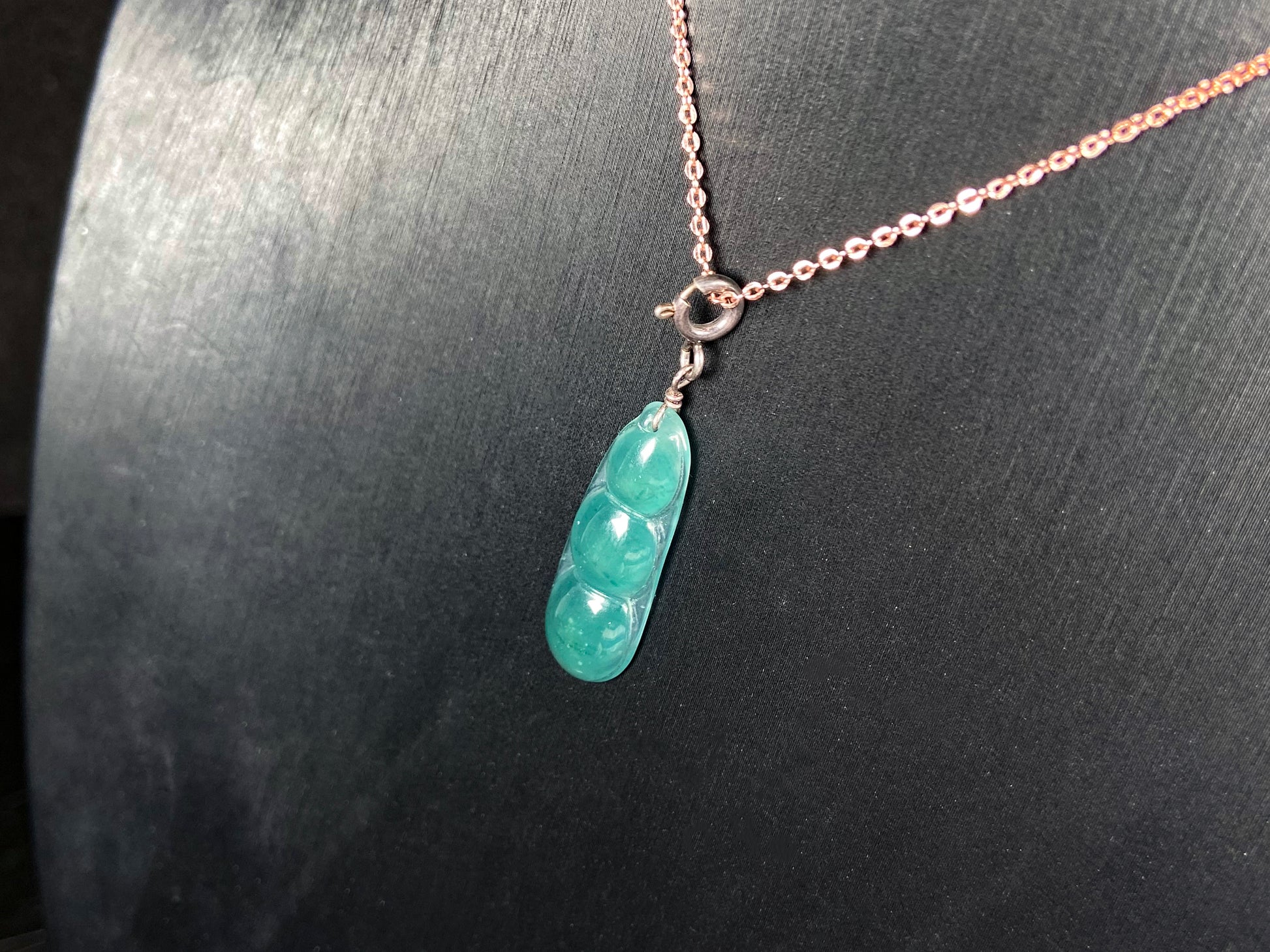 A watery blue lucky pea pod jadeite pendant.