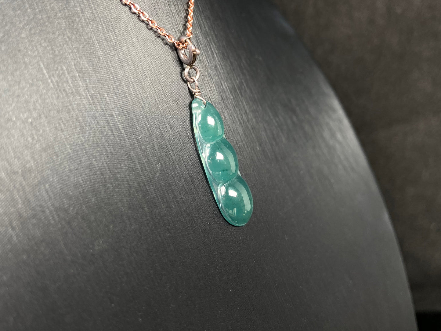 A watery blue lucky pea pod jadeite pendant.