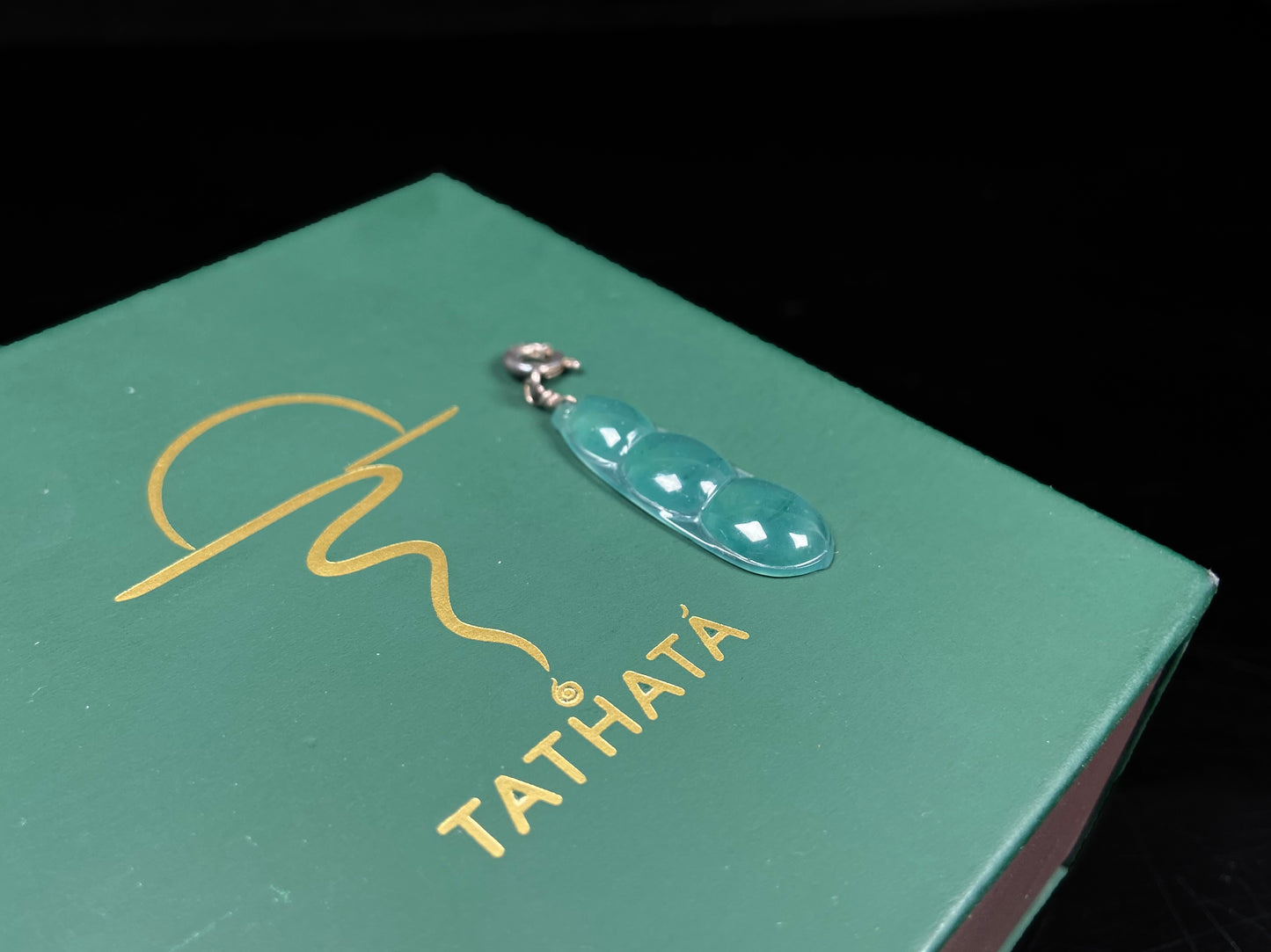 A watery blue lucky pea pod jadeite pendant.