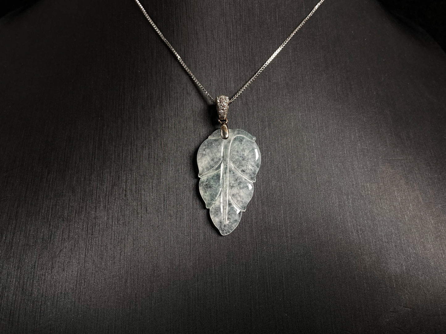 An icy jade leaf pendant, elegant and pure.