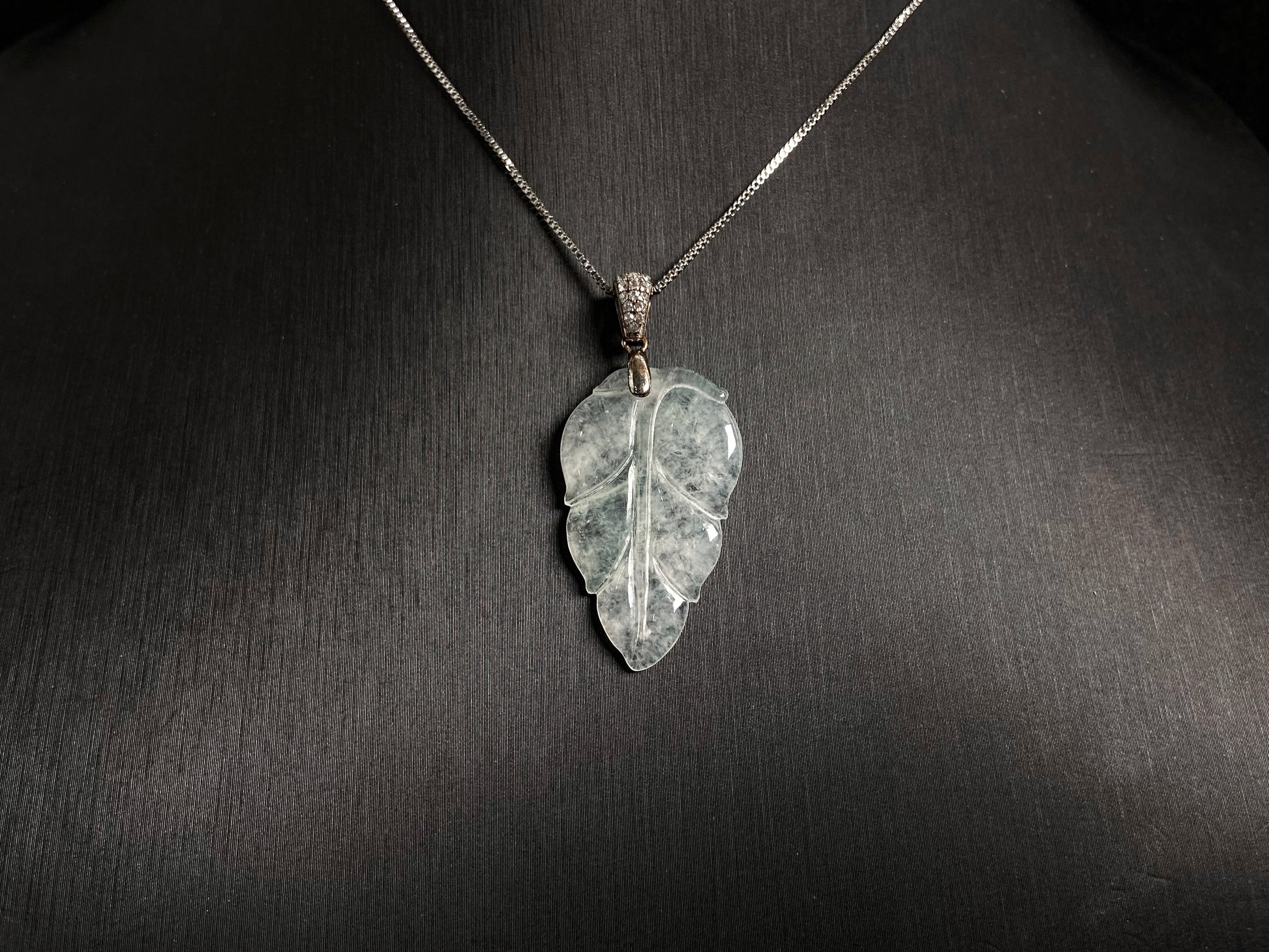 An icy jade leaf pendant, elegant and pure.