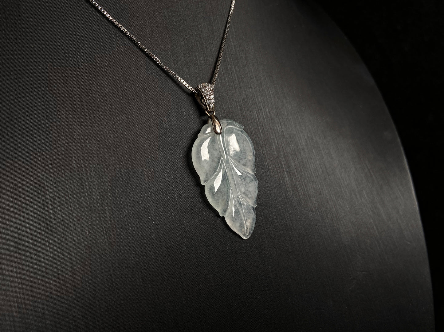 An icy jade leaf pendant, elegant and pure.