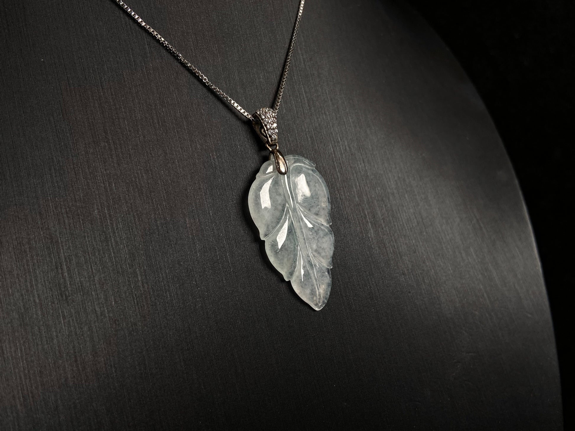 An icy jade leaf pendant, elegant and pure.