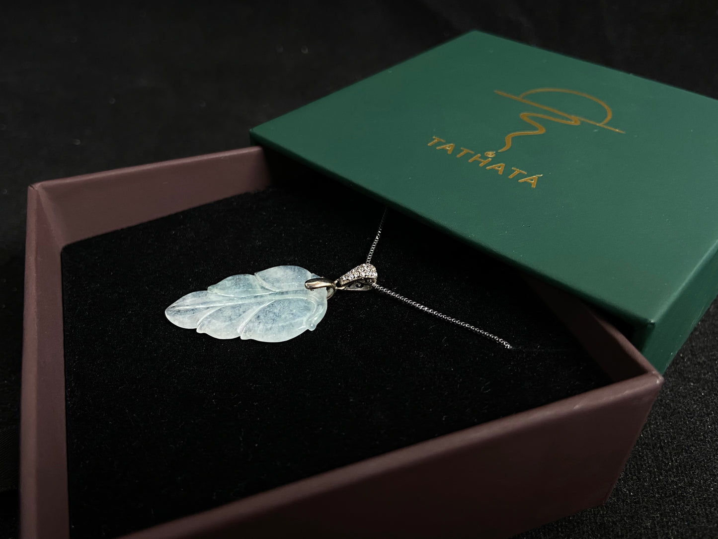 An icy jade leaf pendant, elegant and pure.