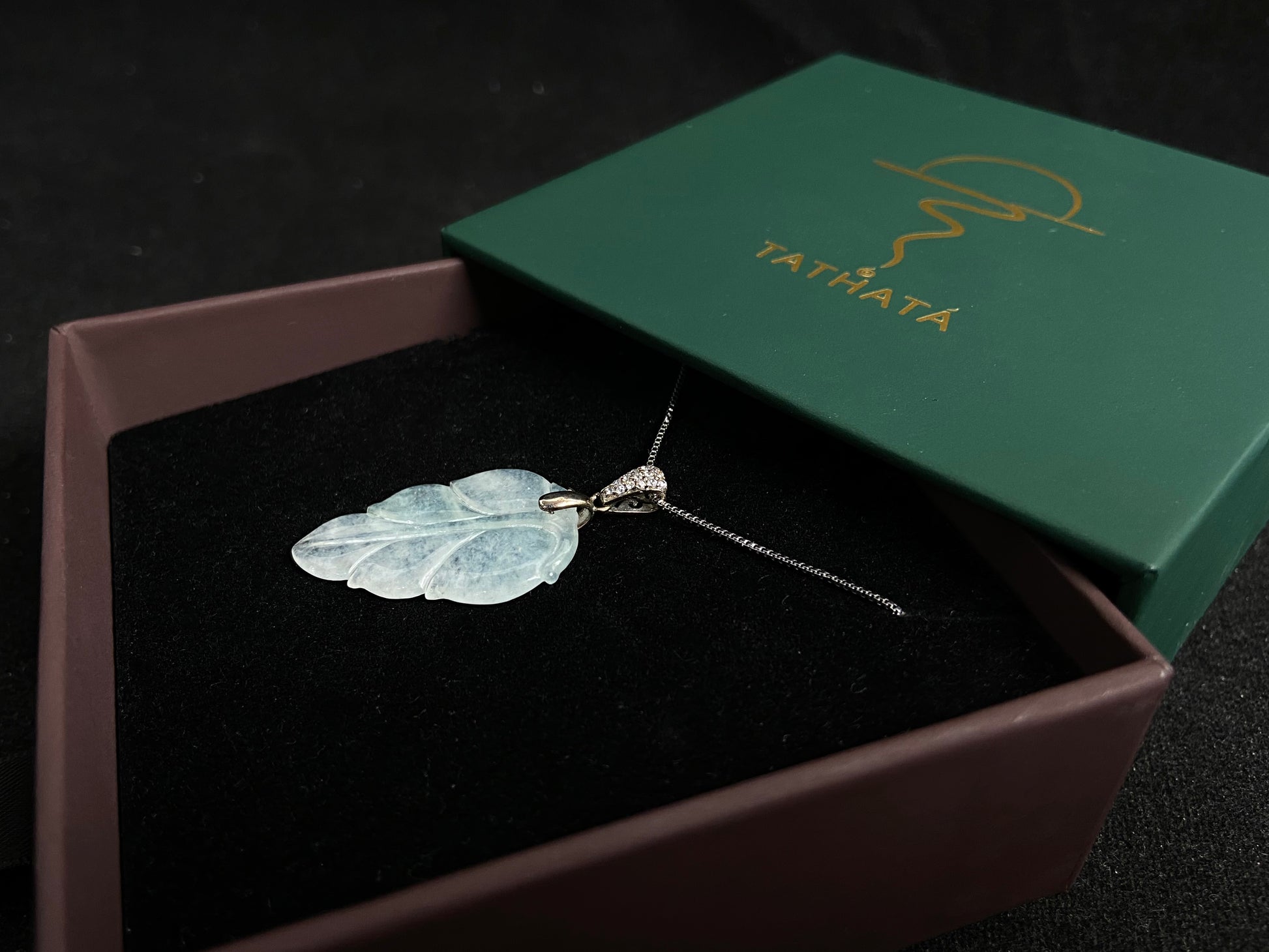 An icy jade leaf pendant, elegant and pure.