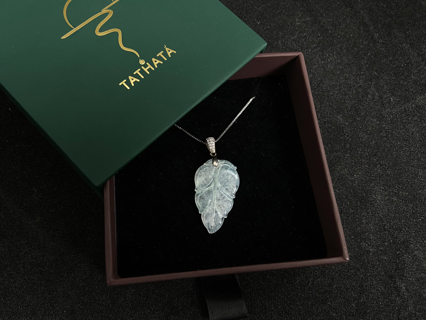An icy jade leaf pendant, elegant and pure.
