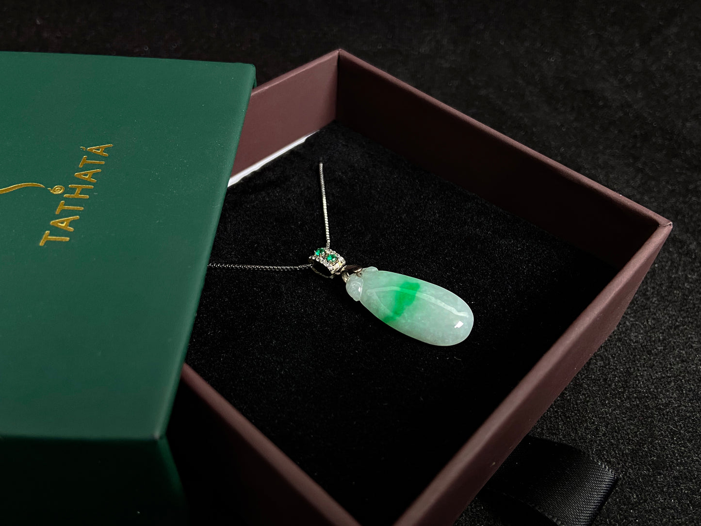 A "Fortune Melon" jade pendant featuring a white base adorned with a soft green accent.