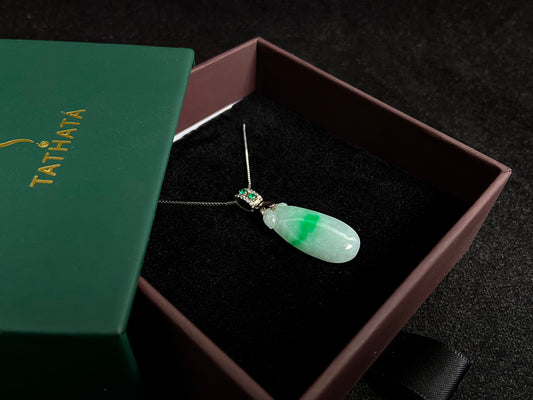 A "Fortune Melon" jade pendant featuring a white base adorned with a soft green accent.