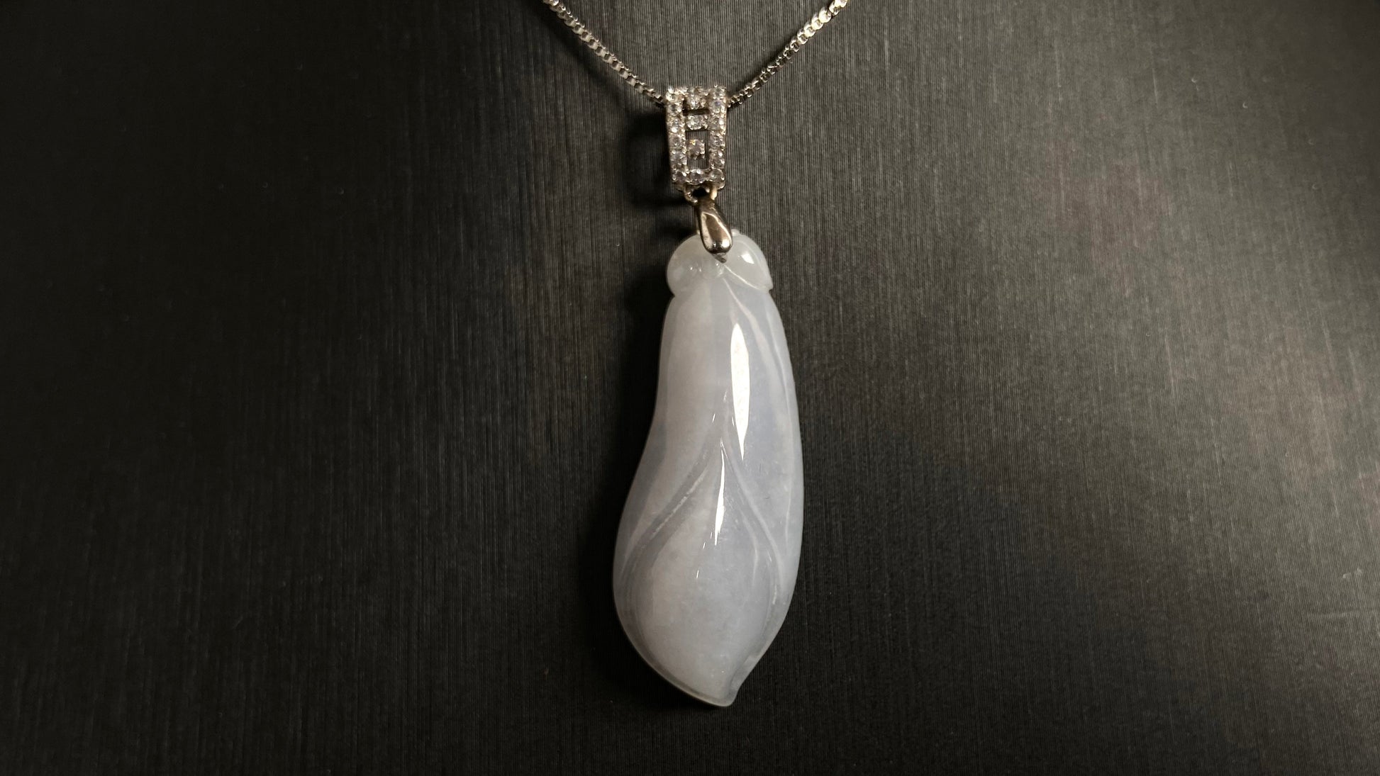 A milky white jade orchid blossom pendant, elegant and pure in its simplicity.