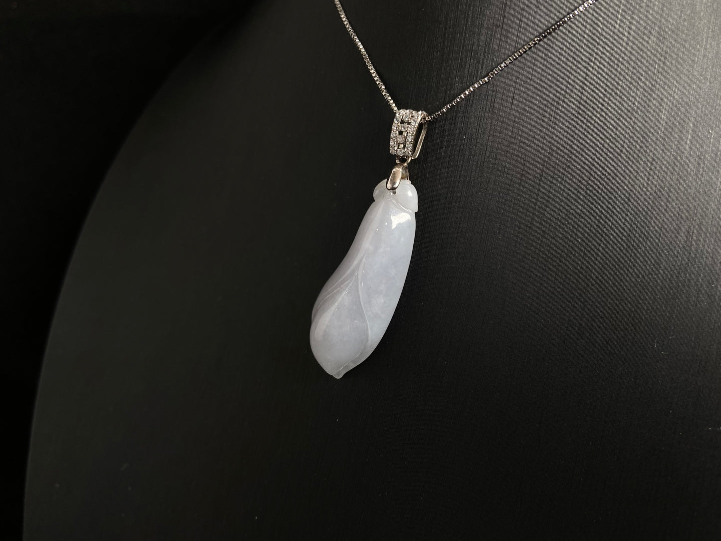 A milky white jade orchid blossom pendant, elegant and pure in its simplicity.
